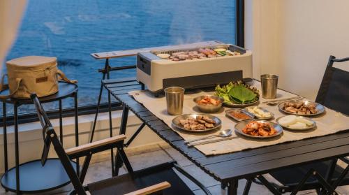 a table with dishes of food on a balcony at Pohang Pine Wave Pension in Pohang