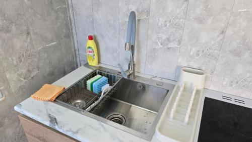 a kitchen sink with a dish drying rack next to it at Danista Nomads Tour Hostel in Ulaanbaatar