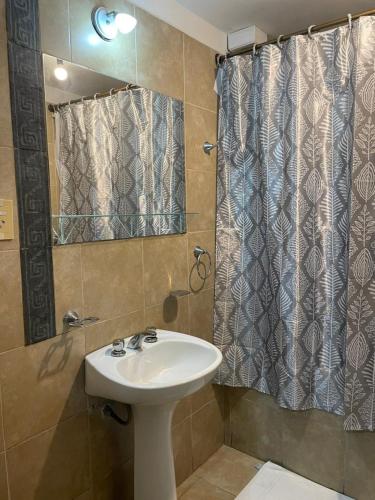 a bathroom with a sink and a shower with a mirror at Benitez Hostería in Calilegua