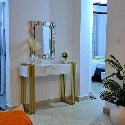 a bathroom with a sink with a mirror on it at RyNa Homes in Meru