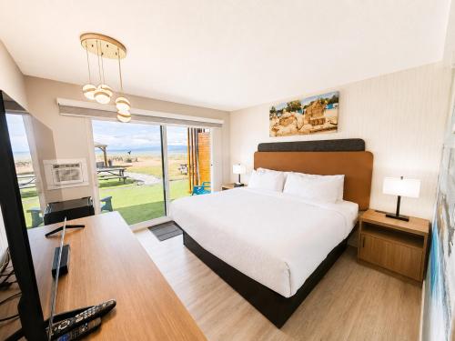 a hotel room with a bed and a desk with a television at Sea Edge Beachside Hotel in Parksville