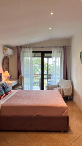 a bedroom with two beds and a balcony at GREEN and BLUE VILLA in Glykadi