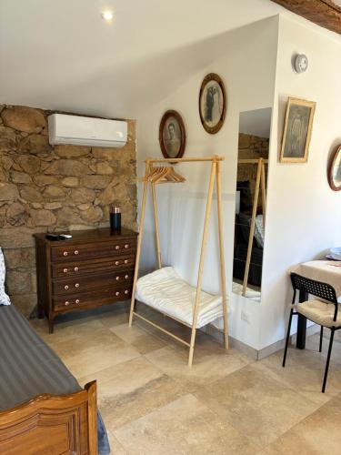 a bedroom with a bed and a dresser and a mirror at Bergerie du Riccio avec piscine privée in Cauro
