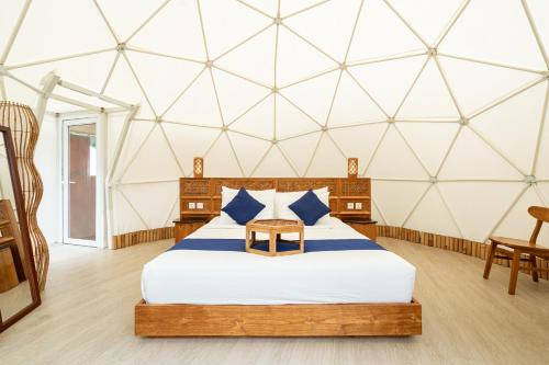 a bedroom with a large bed in a dome tent at Triyana Resort and Glamping Carangsari Bali in Payangan