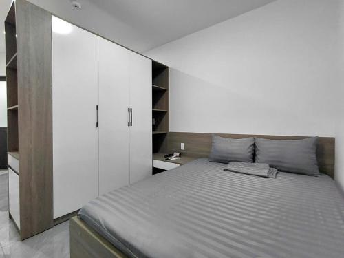 a bedroom with a large bed and a white cabinet at ZENITH STAY by Lan's in Danang