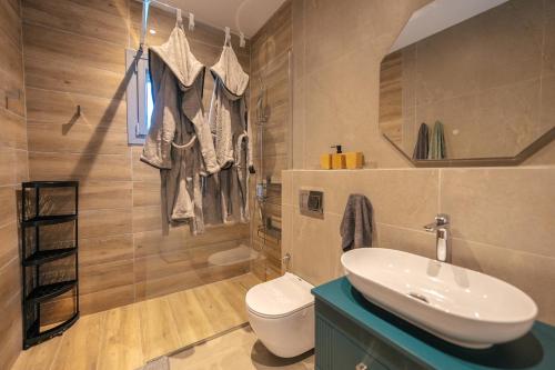 a bathroom with a sink and a toilet and a mirror at Vigla View Sifnos in Vathi