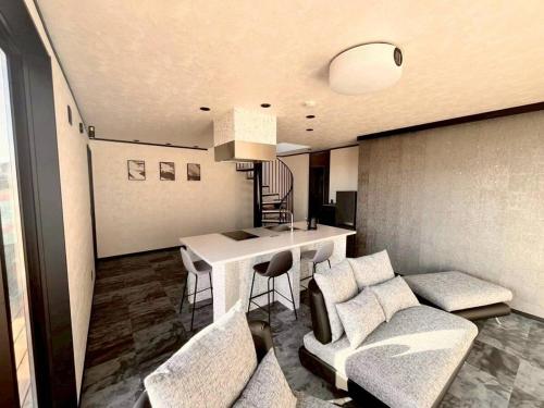 a living room with a couch and a table at Calme Villa in Asahi