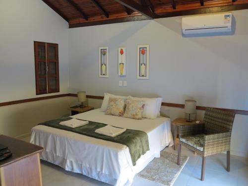 a bedroom with a bed and a chair at Pousada Recanto da Grande Paz in Alto Paraíso de Goiás