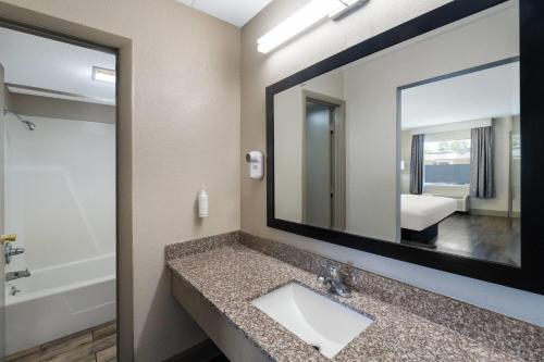 a bathroom with a sink and a mirror at Days Inn by Wyndham Greeneville in Greeneville