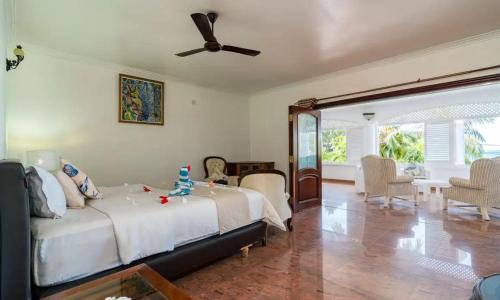 a bedroom with a bed and a ceiling fan at Le Bonheur Villa in Victoria