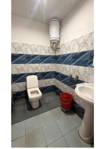 a bathroom with a toilet and a sink at Ekdantam Hotel and Restaurant in Uttarkāshi