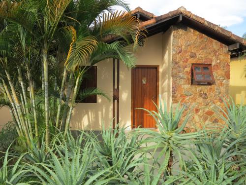 a house with a palm tree in front of it at Pousada Recanto da Grande Paz in Alto Paraíso de Goiás