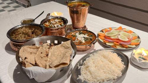 a table with plates of food and bowls of rice at Hotel Dev Darshan in Uttarkāshi