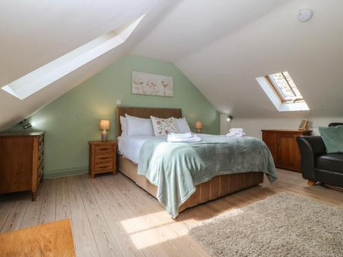 a bedroom with a bed and a chair at No 1 The Granary in Llangefni
