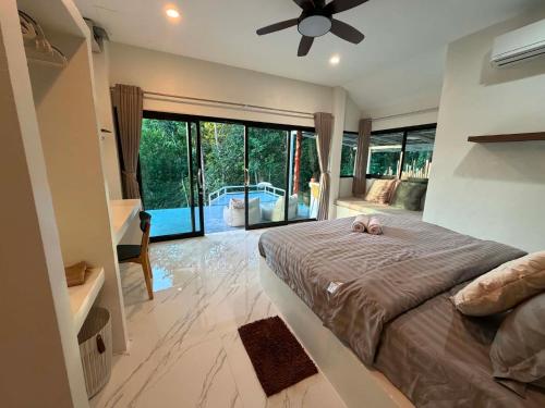 a bedroom with a large bed with a ceiling fan at Khao Raa Terrace @Phangan in Ban Madua Wan