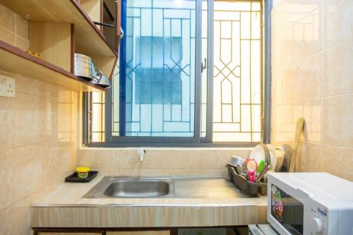 a small kitchen with a sink and a window at Nziwa's Paradise Bamburi in Mombasa