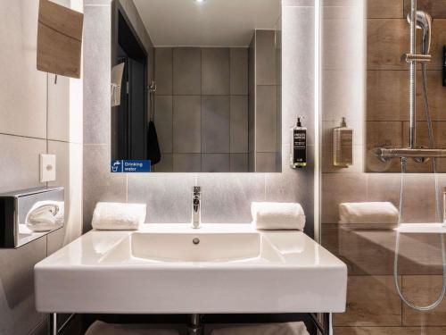 a bathroom with a white sink and a shower at ibis Styles Geneve Palexpo Aeroport in Geneva