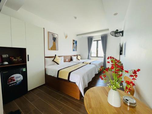 a hotel room with two beds and a table at A90 HOTEl2 in Nhật Tựu