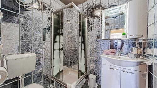 a bathroom with a toilet and a sink and a mirror at Villa Toma by Villas Guide in Orebić