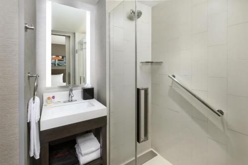 a white bathroom with a sink and a shower at Hyatt Place New York City - Times Square in New York