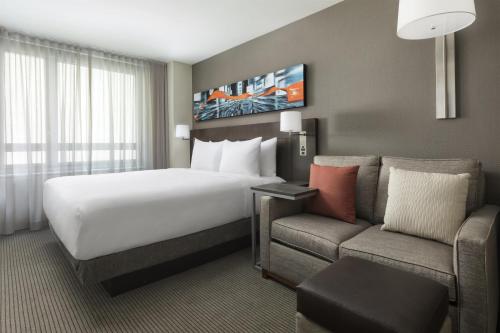 a hotel room with a bed and a couch at Hyatt Place New York City - Times Square in New York