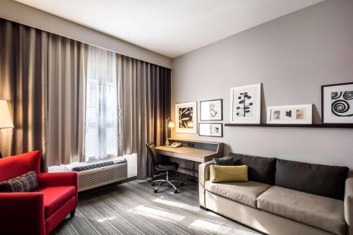 a living room with a couch and a desk in a room at Country Inn & Suites by Radisson, Fond du Lac, WI in Fond du Lac