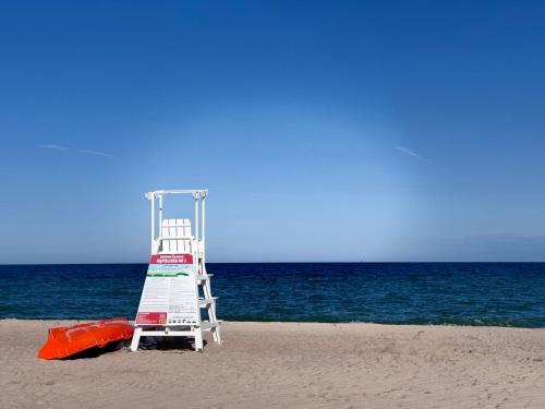 a life guard tower on a beach with the ocean at Domki u Izabeli niedaleko Darłowa in Rusko