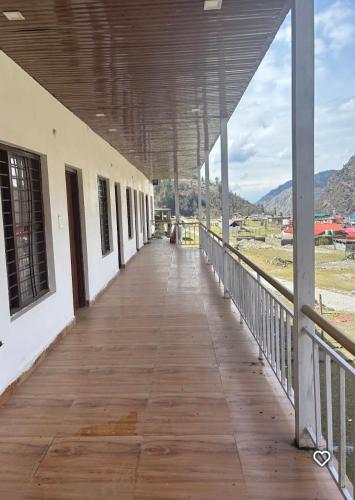an empty hallway of a building with a view of a field at Swastik Hotel & Restaurant in Kharsālī
