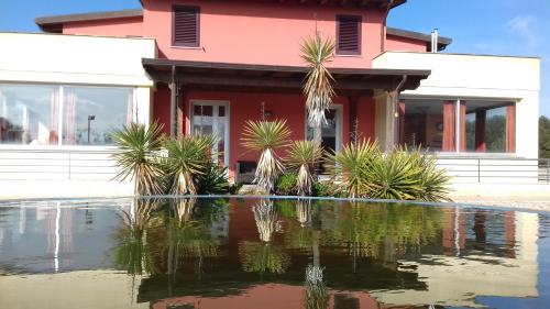 a house with a pond in front of it at B&B Lu Casale in San Cesario di Lecce