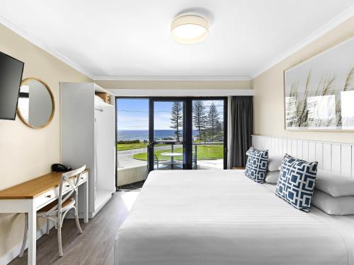 a hotel room with a bed and a desk at ibis Styles Port Macquarie in Port Macquarie