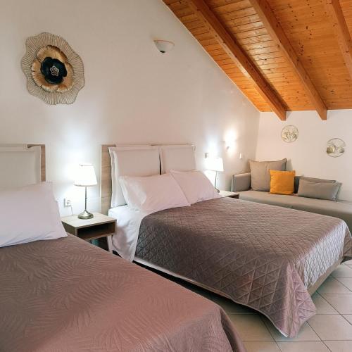 a bedroom with two beds and a couch at Rousis Studios in Parga