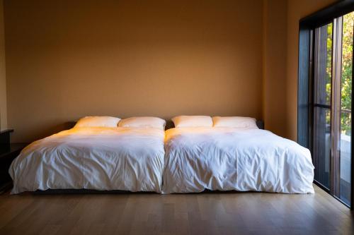 two beds sitting next to each other in a room at Villa LUAR in Minamiawaji