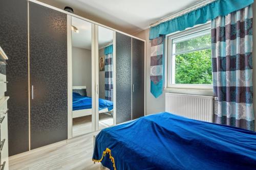 a bedroom with a blue bed and a window at Ferienwohnung Kleinramspau in Regenstauf