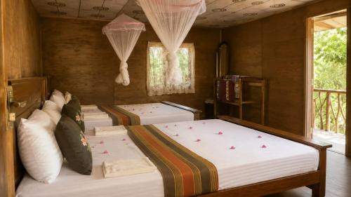 a bedroom with three beds in a room at Sigiri Panaromic Tree House in Sigiriya