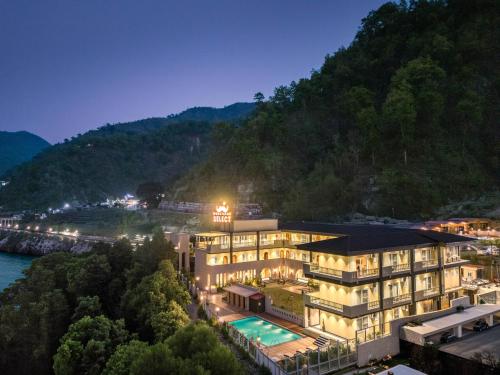 a building with a swimming pool and a mountain at Moustache Select Rishikesh Mohanchatti in Mohan Chatti