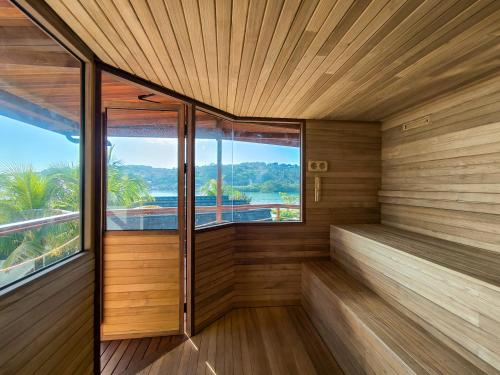 a sauna with wood paneling and windows at Segara Seaside Resort in Nusa Lembongan