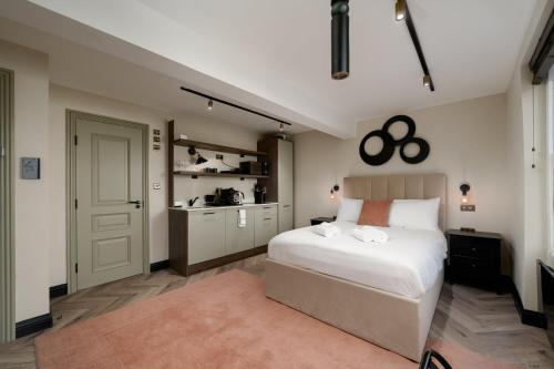 a bedroom with a white bed and a kitchen at GuestReady - The Euston in London