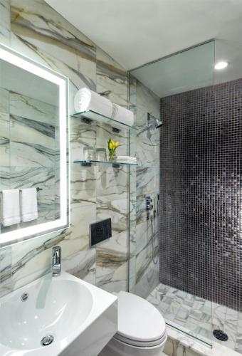 a bathroom with a sink and a toilet and a shower at Dream Midtown, by Hyatt in New York
