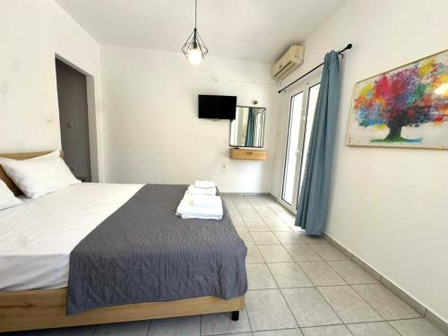 a bedroom with a bed and a tv in it at Enjoy Parga Appartments in Parga