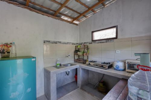 a kitchen with a counter and a sink and a window at Kapouk Cottage in Nusa Penida