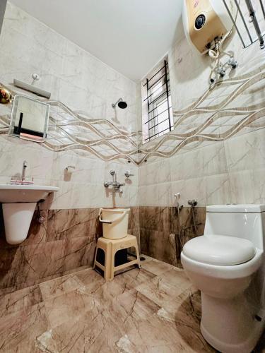 a bathroom with a toilet and a sink at IMPERIAL COTTAGE, HILL BUNK OOTY in Ooty