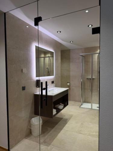 a bathroom with a sink and a shower and a mirror at Hotel Gasthof Neuner in Imst