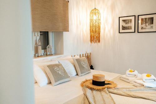 a bedroom with a bed with towels and a hat on it at Naias View Home Milos in Adamantas