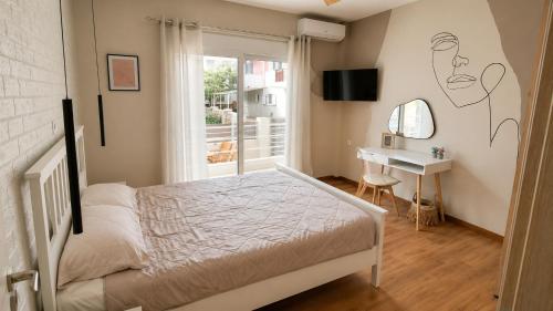 a bedroom with a bed and a desk and a window at Limera View Monemvasia in Monemvasia