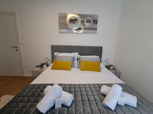 a bedroom with a large bed with yellow and white pillows at Luxury Mint Garden Apartment in Kaštela