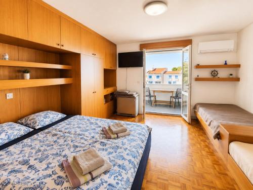 a bedroom with a bed and a balcony with a table at Apartments Pika in Krk