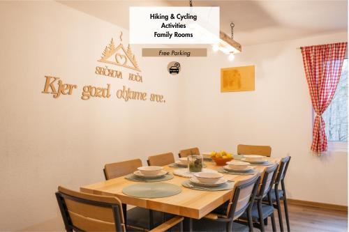 a dining room table with chairs and a sign on the wall at Srčkova Koča in Kočevje