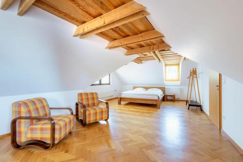 a living room with two chairs and a bed at Kralova Apartment in Modra in Modra