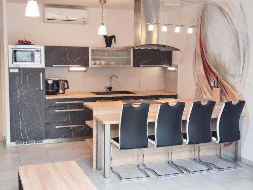a kitchen with a wooden table and black cabinets at Apartmány Duo in Dačice