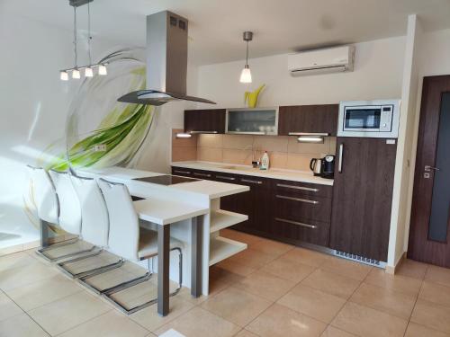 a kitchen with a white table and white chairs at Apartmány Duo in Dačice